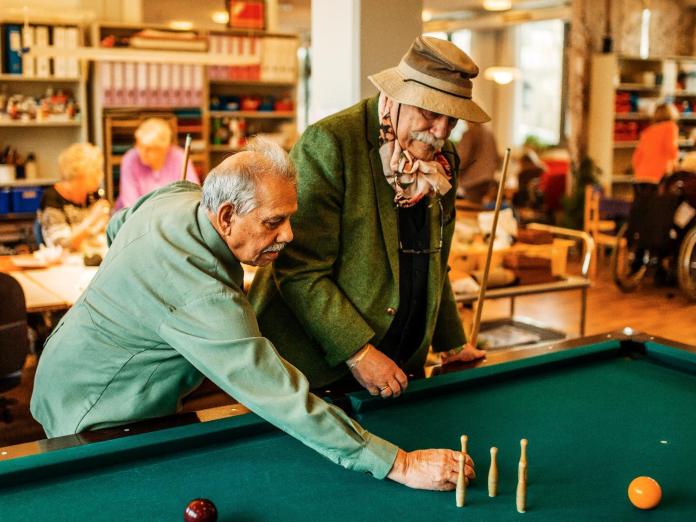 To ældre mænd spiller billard. 