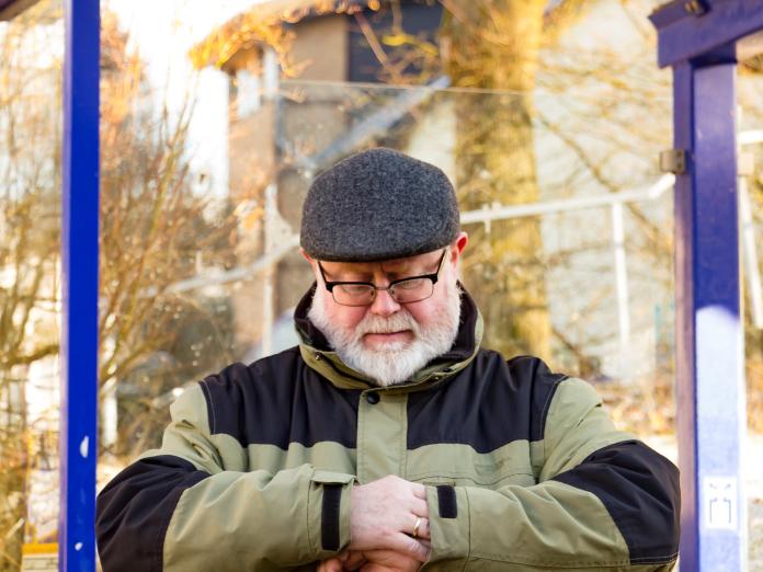 Billede af en mand, der står under et overdække.
