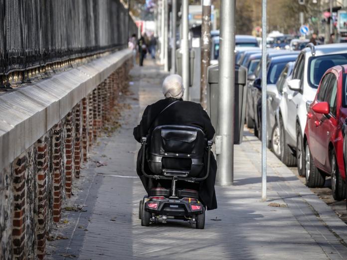 Billede af en el-scooter, der kører på et fortov.