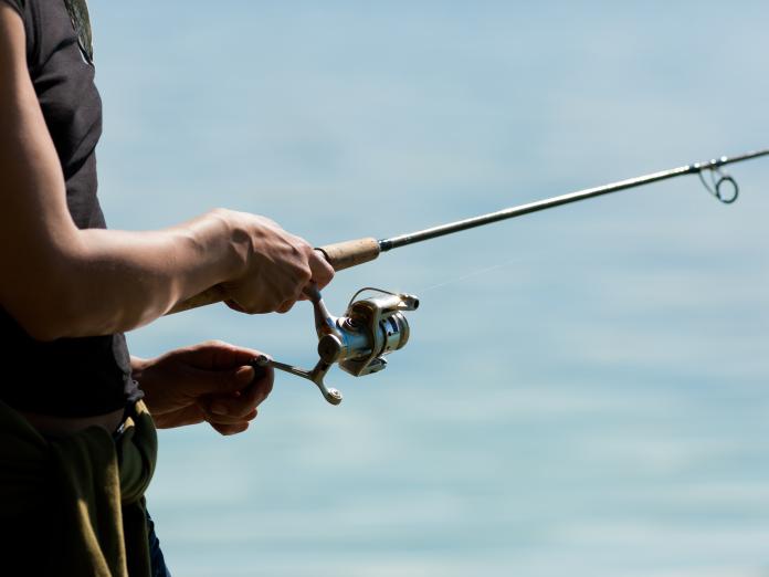 Person står med fiskestang